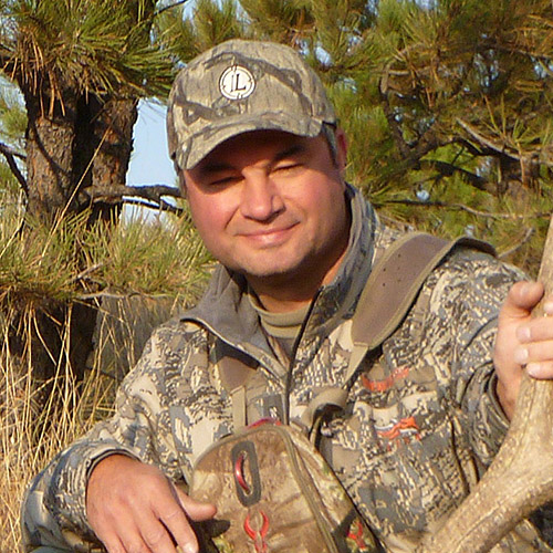 Keith Balfourd wearing camo by a tree
